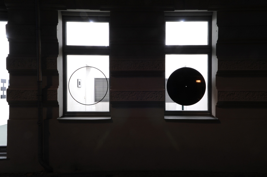 Two single holes, 2013. Black adhesive foil, diameter 80 cm each. Night view outside.